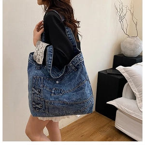 Detail of a large denim tote bag featuring vintage jean elements and side cross-lacing