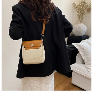 Detail of color-block canvas and leather shoulder bag with vintage round metal buckle