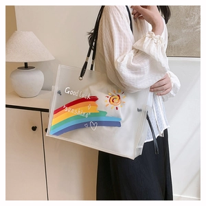 Detail of semi-transparent white beach tote with rainbow print and thin black straps