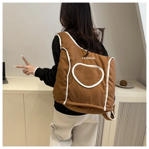 Détail d'un sac fourre-tout matelassé marron avec motif de cœur et texte de mode