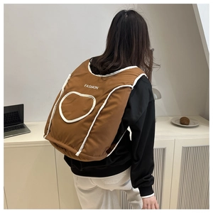 Gros plan d'un sac à dos matelassé marron avec liseré blanc et logo Fashion au dos