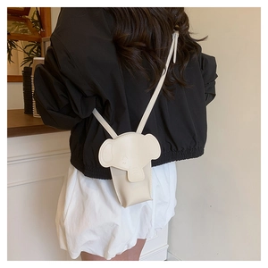 Close-up of a cream elephant-shaped mini crossbody bag with a slim leather strap