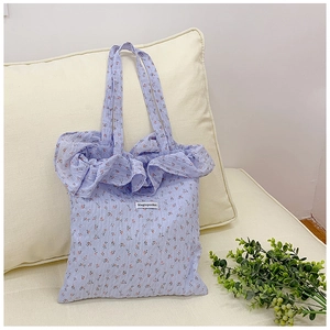 Detail of lavender floral tote bag featuring ruffled edges and Magiopocket brand label