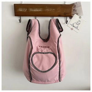 Gros plan du harnais rose pour animaux avec poche coeur et imprimé sur nylon