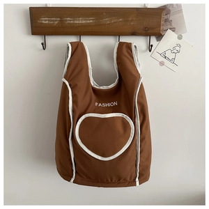 Détail d'un sac cabas marron avec passepoil blanc et grand motif de cœur blanc élégant