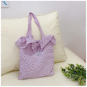 Detailed close-up of purple floral tote bag with ruffle trim and textured fabric