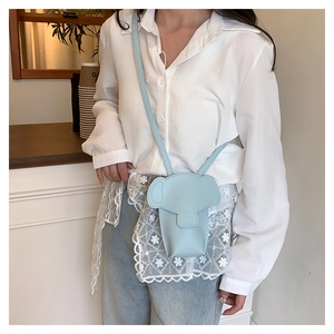 Detail of light blue elephant-shaped mini crossbody bag worn by a model in casual setting
