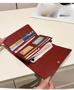 Détail du portefeuille long en similicuir rouge avec compartiments pour cartes et téléphone