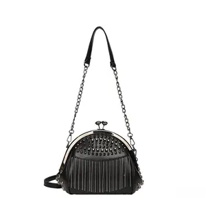 Detail of vintage black shell bag with silver rivets and metal tassel fringes