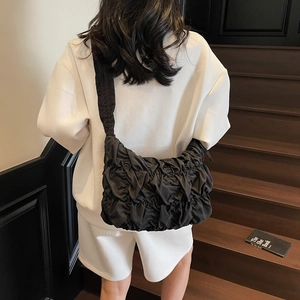 Borsa tote nera a pieghe in nylon testurizzato mostrata su una modella in stile casual