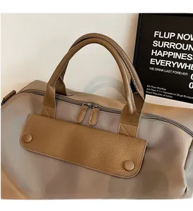 Detail of reinforced brown leather handles and high-density nylon fabric on travel bag