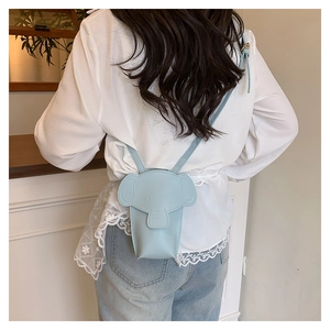 Detail of light blue elephant crossbody bag showing size and 3D ear accents on a model