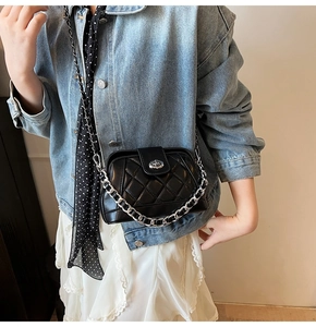 Borsa a tracolla trapuntata nera con catene d'argento indossata da una modella con outfit casual