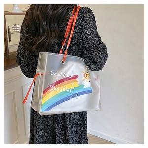 Detail of the transparent PVC beach tote featuring rainbow prints and orange straps