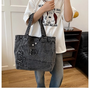 Detail of deconstructed denim tote bag with metal buttons and criss-cross side laces