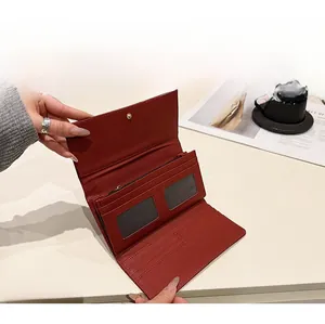 Portefeuille en cuir bordeaux avec fentes pour cartes et poche monnaie sur une table