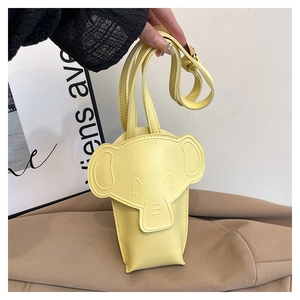 Detail of yellow elephant shaped mini crossbody bag with cute ear and embossed eye details