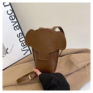 Detail of dark brown elephant-shaped crossbody bag with 3D ears and adjustable strap