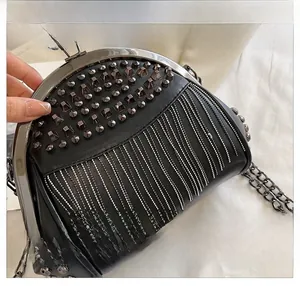 Detail of black leather bag with metal tassels and pyramid stud decorations