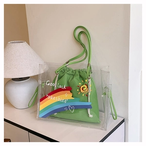Detail of transparent PVC tote bag with a green canvas inner pouch and colorful artwork