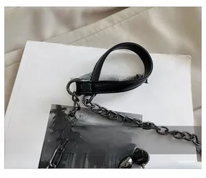 Detail of black leather handle with dark grey metal chain and ball charm accents