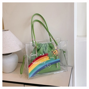 Close-up of transparent PVC tote bag with green drawstring inner pouch and text design