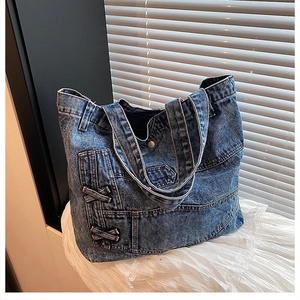 Close-up of dark blue denim tote bag with vintage jeans pockets and lace background