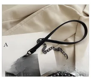 Detail of black leather bag with metal rivets and stylish chain shoulder strap