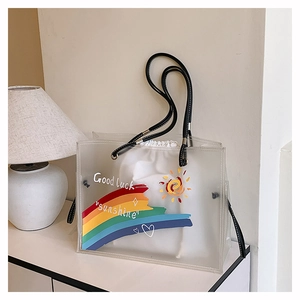 Detailed shot of transparent rainbow tote with Good Luck lettering and canvas inner bag