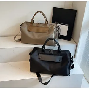 Detailed view of durable nylon travel bags in khaki and black with sturdy leather handles