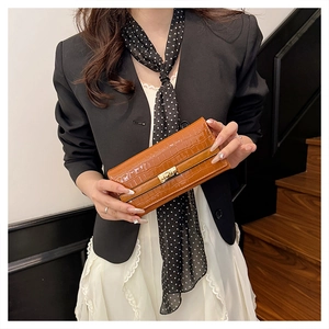 Détail de la pochette effet crocodile caramel avec boucle en métal doré élégante