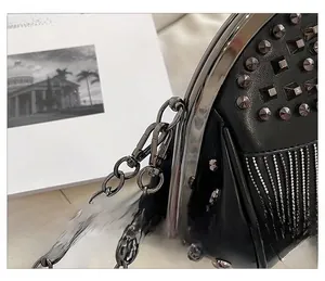 Detail of black leather bag featuring metallic rivets and a detachable thick chain strap