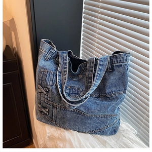 Detail showing deconstructed blue denim tote bag with visible stitching and lace background