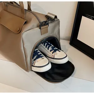 Detail showing an integrated side shoe compartment on a durable khaki travel duffel bag