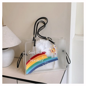 Detailed view of clear PVC tote bag with colorful rainbow print and drawstring liner