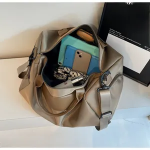 Top view of open khaki travel bag showing spacious interior and adjustable strap