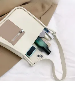 Detail view of cream leather shoulder bag interior showing spacious storage for cosmetics