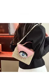 Detail of hand-woven straw bag with pink leather flap and beaded eye embroidery