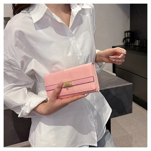 Détail d'une pochette en cuir verni rose clair avec boucle carrée dorée