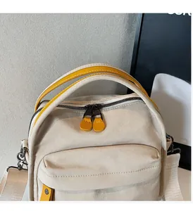 Detail of beige canvas tote with yellow contrast handles and double zipper closure