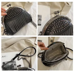 Detail view of black punk style rivets and dense fringes on this crossbody shell bag