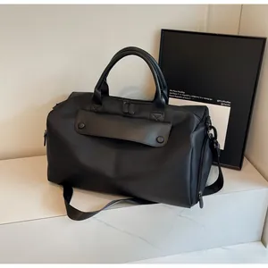 Detail of black waterproof Oxford cloth travel bag with reinforced handles and shoulder strap