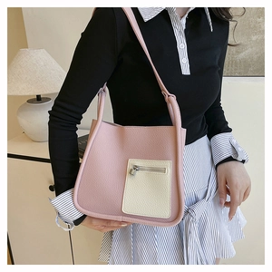 Detail of pink lychee texture shoulder bag with off-white pocket and silver lock hardware