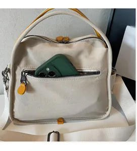 Close-up of beige canvas bag with front zipper pocket showing spacious phone compartment