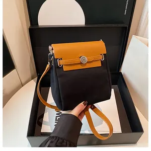 Detail of color-block flap bag in black canvas and ginger leather with silver buckle