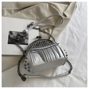 Detailed shot of silver shell bag featuring metal tassel chains and rivet decorations