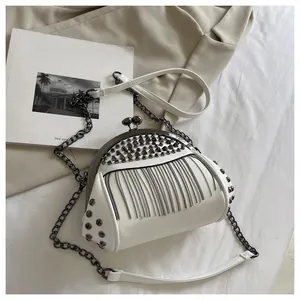 Close-up of white crossbody bag with dark grey metal rivets and dense chain fringe detail