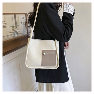 Detail of off-white lychee leather shoulder bag with brown pocket and metal zipper charm