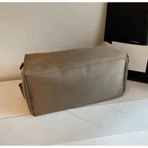 Detailed side and bottom view of khaki nylon travel bag with metal zippers and buckles