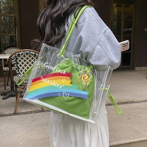 Outdoor shot of a chic two-in-one clear PVC tote bag with green canvas drawstring inner pouch